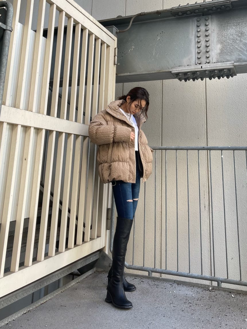 ブルー系のデニムパンツ、ブラック系のブーツ、ホワイト系のTシャツ/カットソーを着用したレディースの秋コーディネートの4枚目の写真