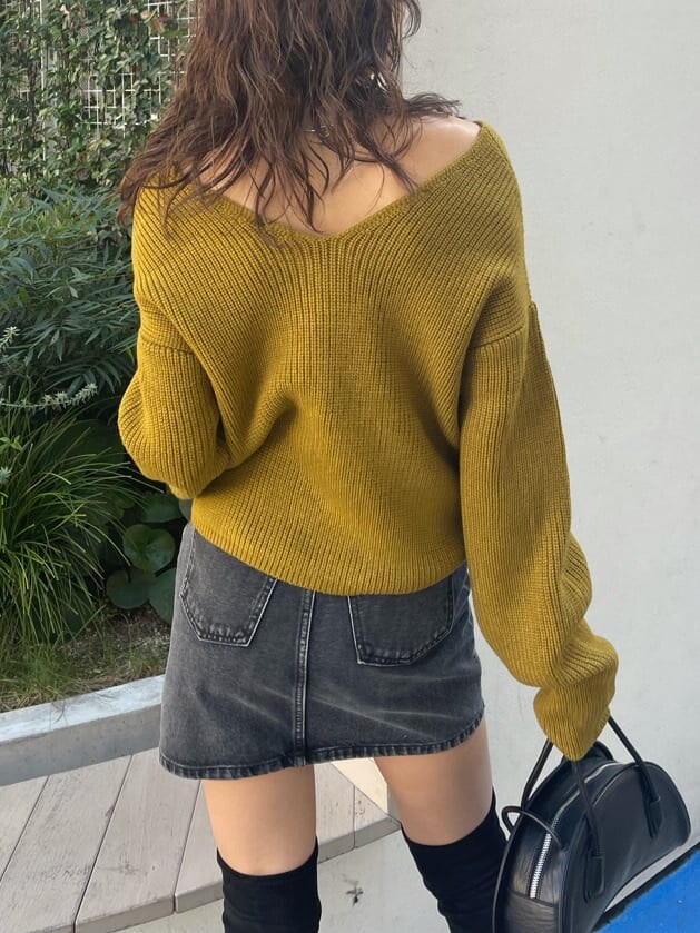 ブラック系のブーツ、ブラック系のハンドバッグ、イエロー系のニット/セーターを着用したレディースの秋コーディネートの4枚目の写真