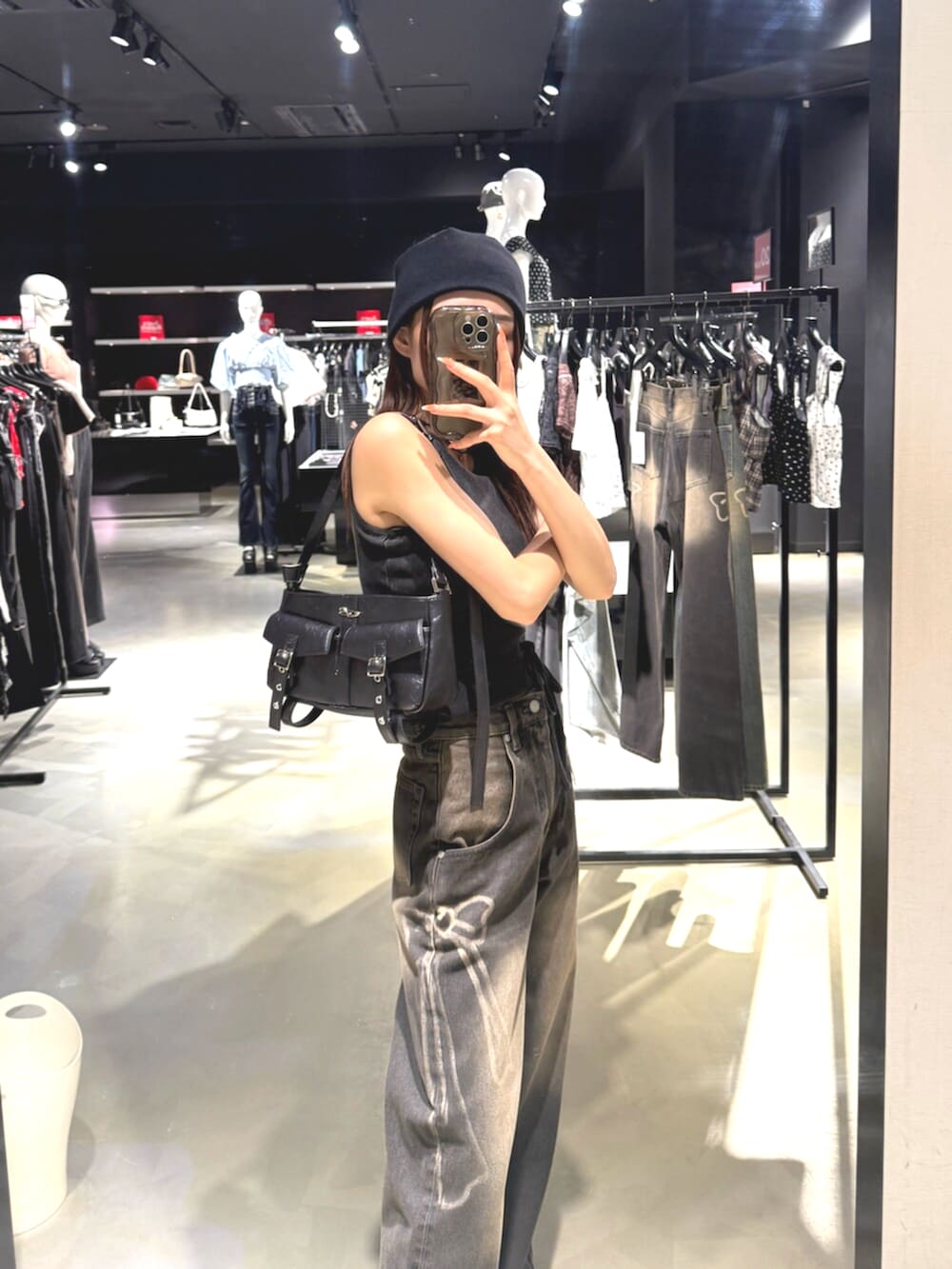 ブラック系のデニムパンツ、ブラック系のTシャツ/カットソー、グレー系のスニーカーを着用したレディースの夏コーディネートの6枚目の写真