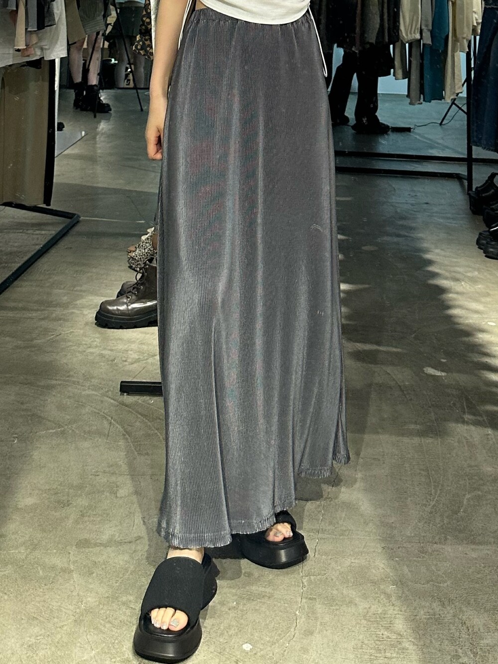 グレー系のスカート、ブラック系のサンダル、ホワイト系のTシャツ/カットソーを着用したレディースの夏コーディネートの6枚目の写真