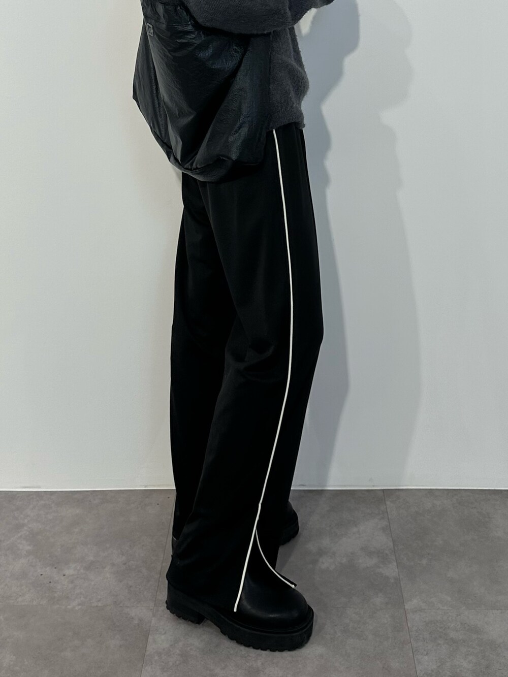 ブルー系のニット/セーター、ブラック系のスラックス、ブラック系のブーツを着用したレディースの冬コーディネートの6枚目の写真