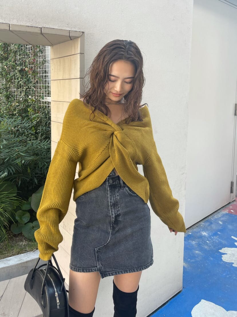 ブラック系のブーツ、ブラック系のハンドバッグ、イエロー系のニット/セーターを着用したレディースの秋コーディネートの3枚目の写真