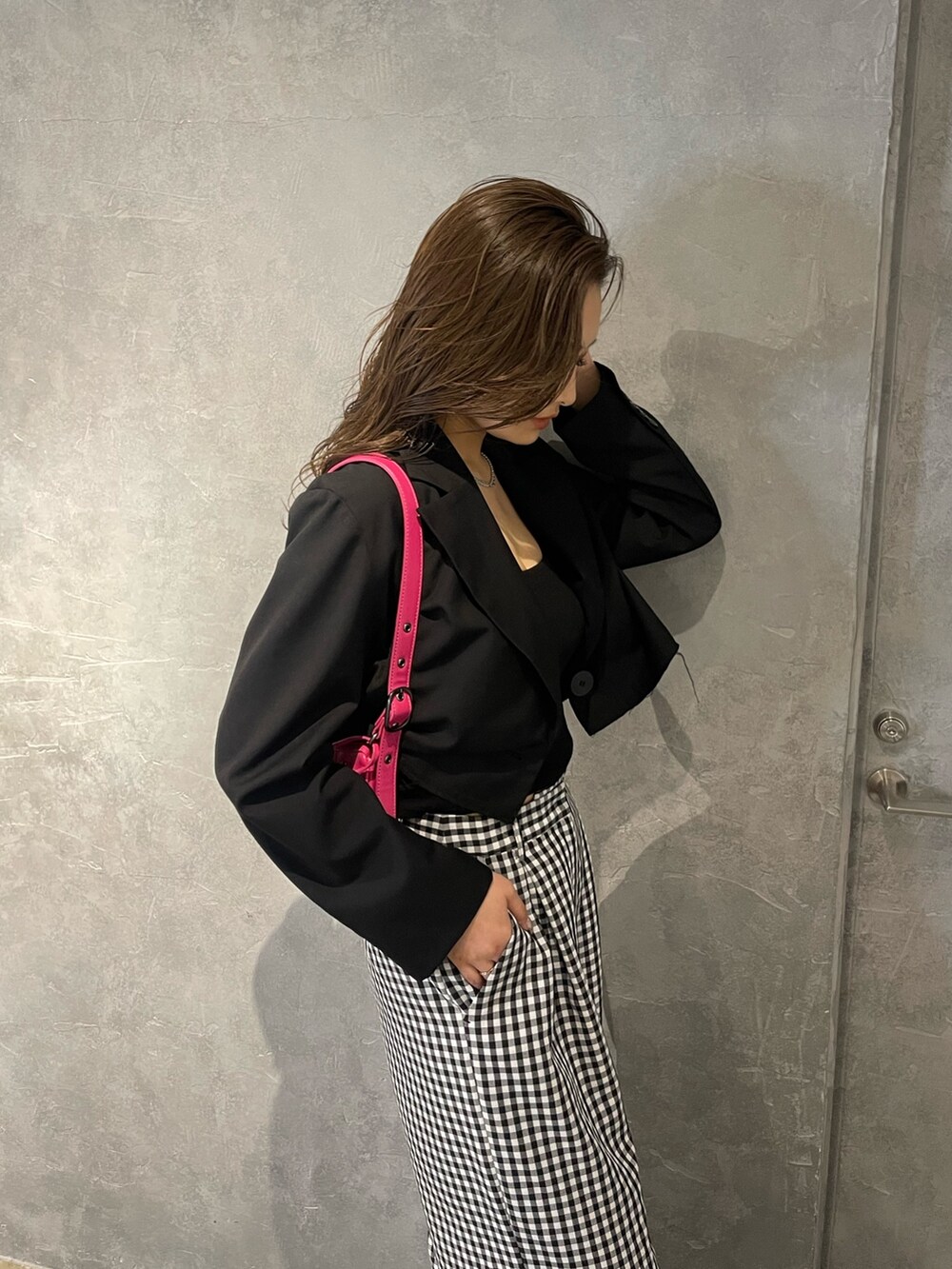 ピンク系のハンドバッグ、ブラック系のパンプス、ブラック系のテーラードジャケットを着用したレディースの冬コーディネートの4枚目の写真