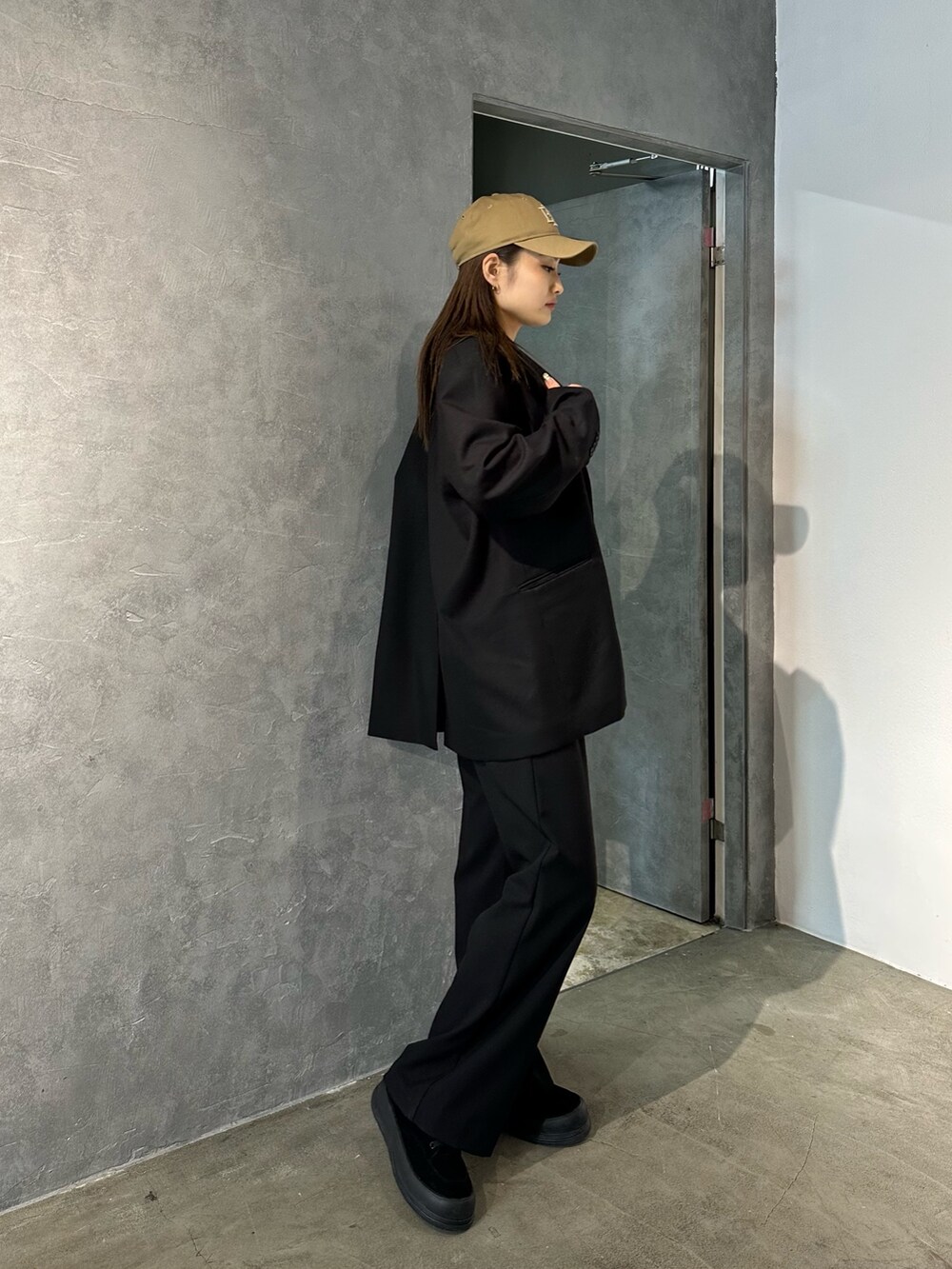 ブラック系のその他パンツ、ブラック系のテーラードジャケット、ブラック系のスニーカーを着用したレディースの冬コーディネートの2枚目の写真