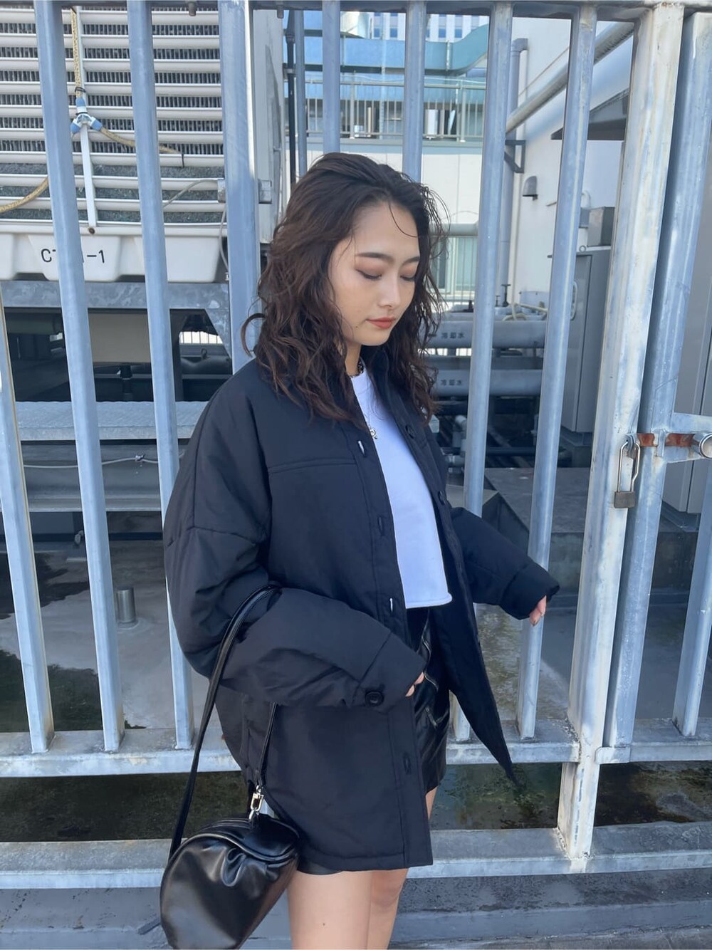 ブラック系のブルゾン、ブラック系のスカート、ホワイト系のTシャツ/カットソーを着用したレディースの秋コーディネートの3枚目の写真