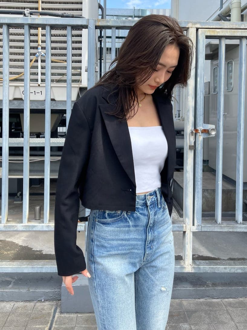 ブラック系のテーラードジャケット、ブルー系のデニムパンツ、ブラック系のブーツを着用したレディースの春コーディネートの5枚目の写真