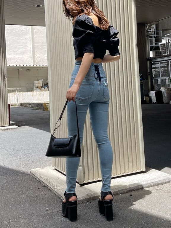 ブラック系のサンダル、ブラック系のTシャツ/カットソー、ブルー系のデニムパンツを着用したレディースの夏コーディネートの2枚目の写真