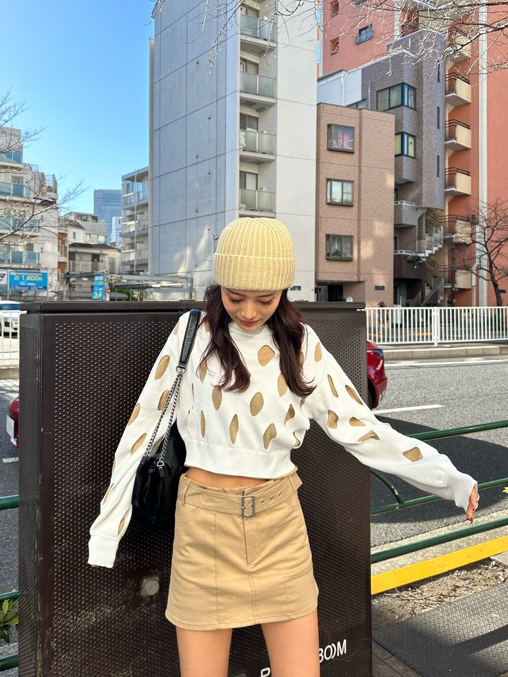 ベージュ系のスカート、ブラック系のブーツ、ホワイト系のニット/セーターを着用したレディースの冬コーディネートの2枚目の写真