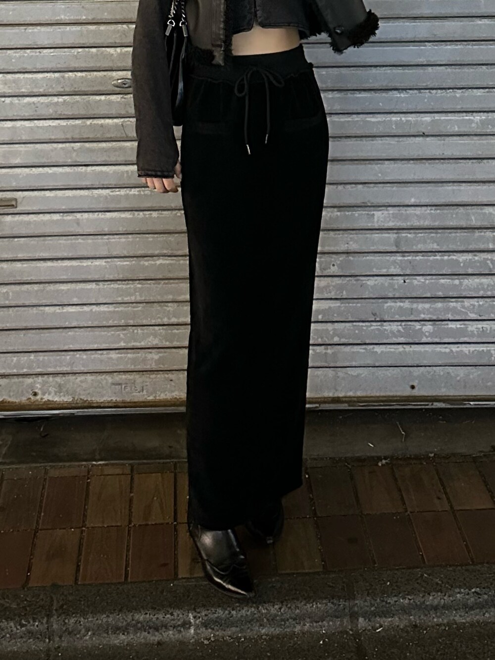 ブラック系のスカート、ブラック系のブーツ、ブラック系のハットを着用したレディースの冬コーディネートの7枚目の写真