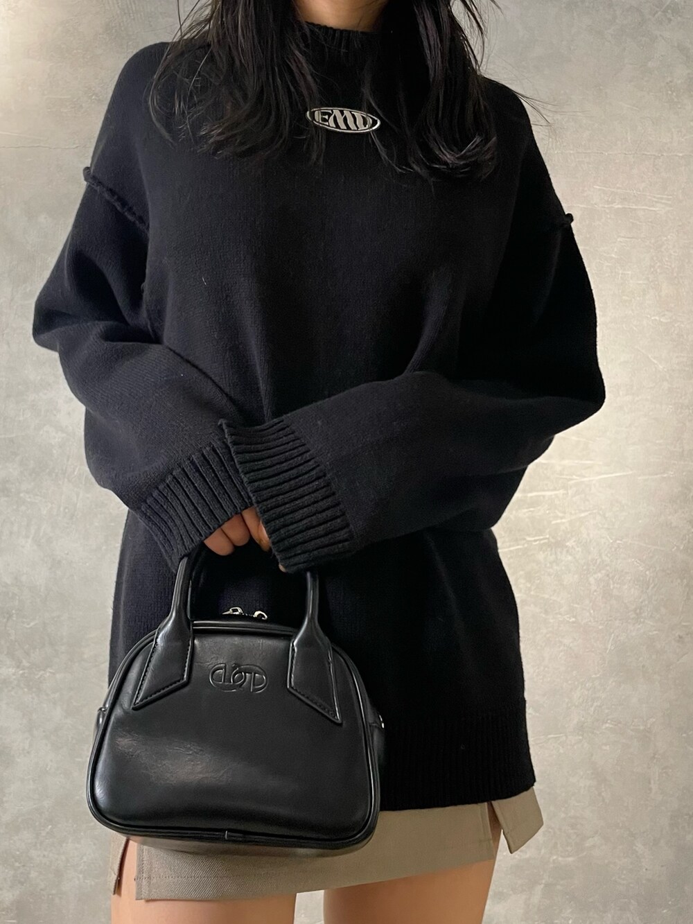 ブラック系のニット/セーター、ベージュ系のスカート、ブラック系のブーツを着用したレディースの冬コーディネートの5枚目の写真