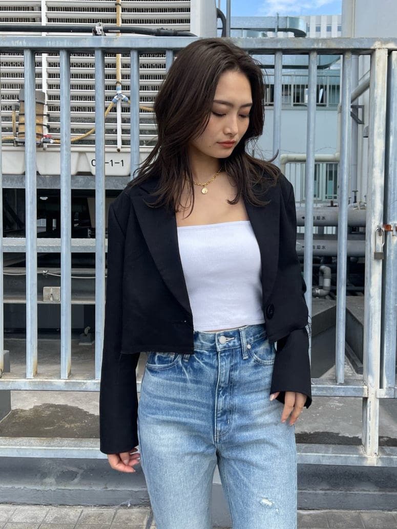 ブラック系のテーラードジャケット、ブルー系のデニムパンツ、ブラック系のブーツを着用したレディースの春コーディネートの6枚目の写真