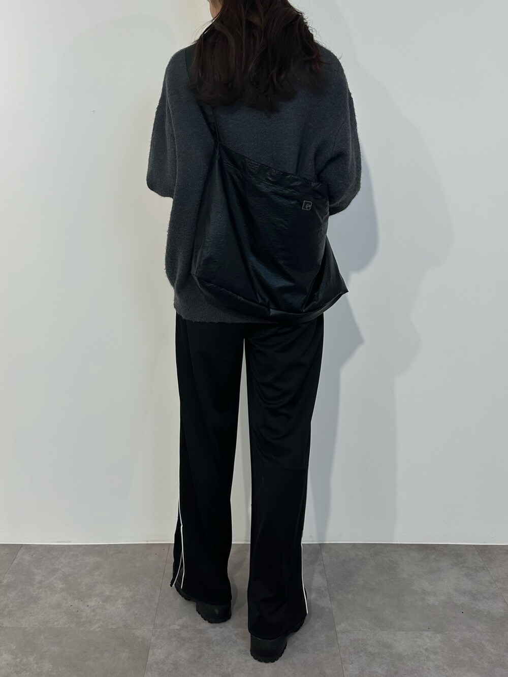 ブルー系のニット/セーター、ブラック系のスラックス、ブラック系のブーツを着用したレディースの冬コーディネートの3枚目の写真