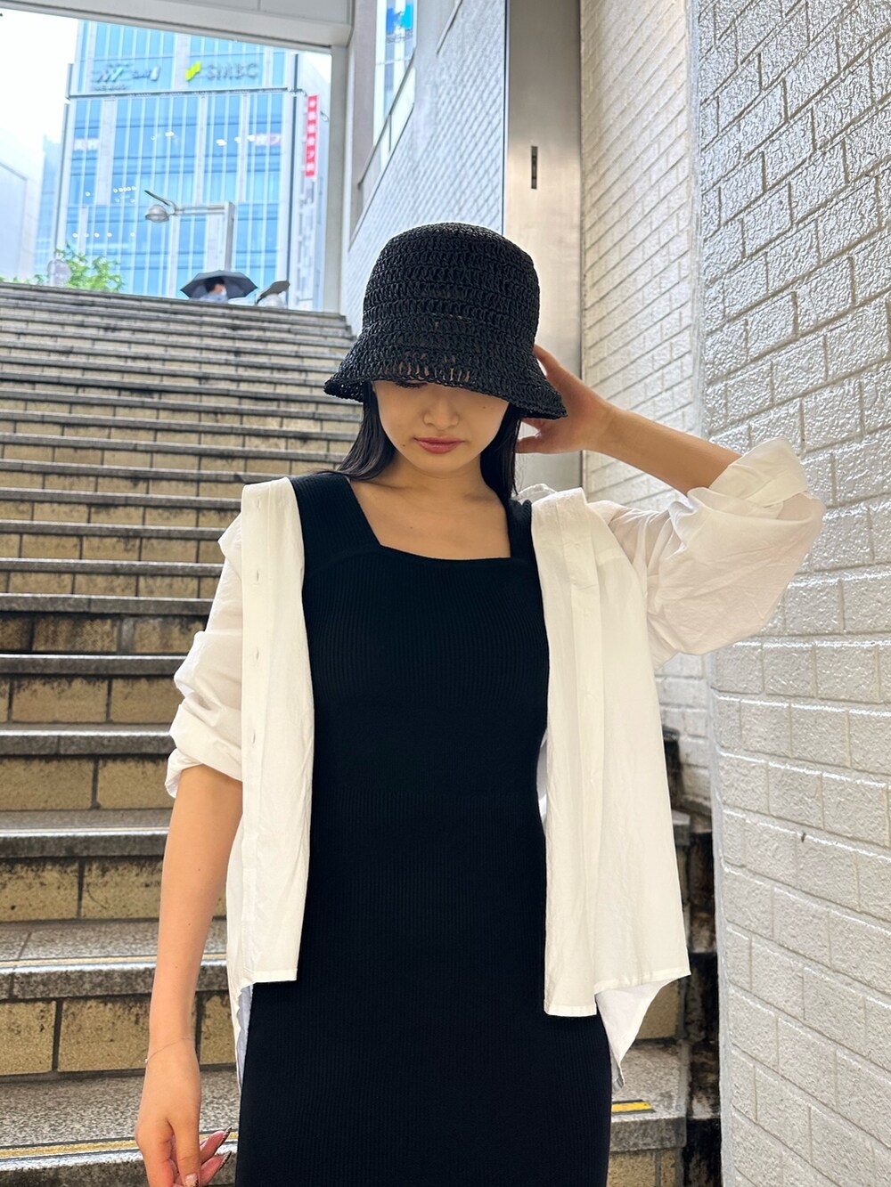 ブラック系のワンピース、ホワイト系のシャツ/ブラウス、ホワイト系のサンダルを着用したレディースの春コーディネートの4枚目の写真