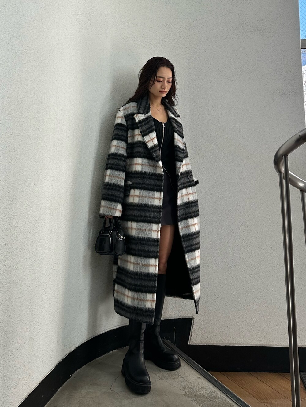 グレー系のスカート、ブラック系のニット/セーター、その他のチェスターコートを着用したレディースの冬コーディネートの2枚目の写真