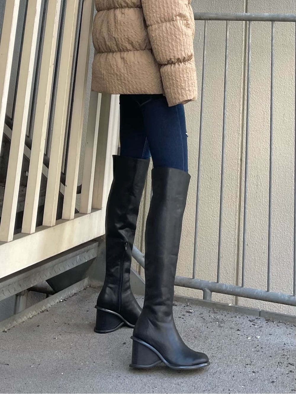 ブルー系のデニムパンツ、ブラック系のブーツ、ホワイト系のTシャツ/カットソーを着用したレディースの秋コーディネートの9枚目の写真