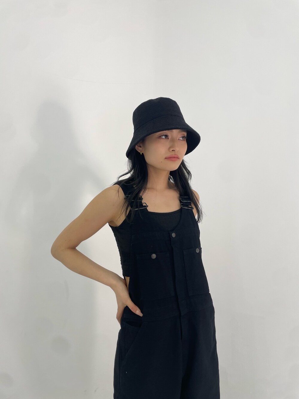 ブラック系のサロペット/オーバーオール、ホワイト系のハンドバッグ、ブラック系のサンダルを着用したレディースの春コーディネートの4枚目の写真