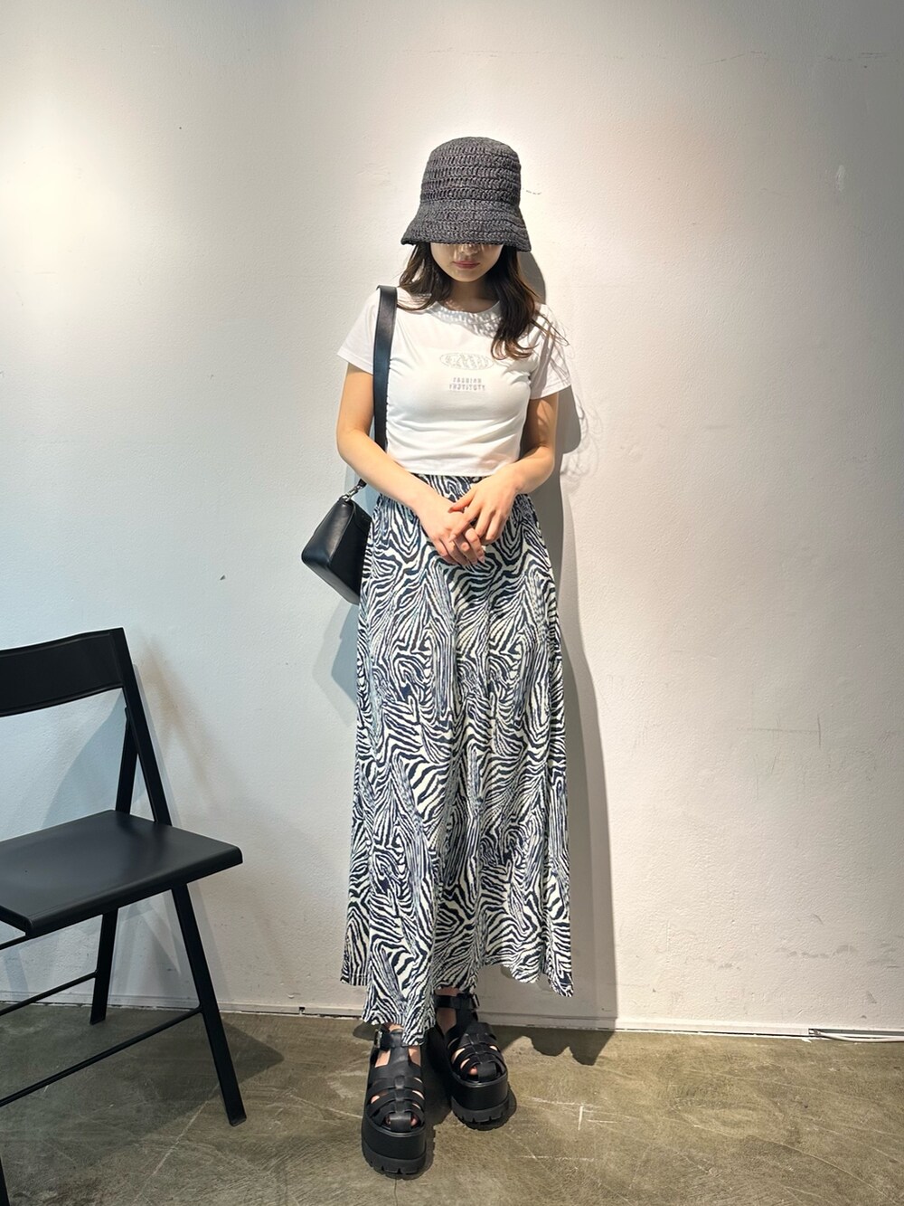 その他のスカート、ブラック系のショルダーバッグ、ブラック系のサンダルを着用したレディースの春コーディネートの2枚目の写真