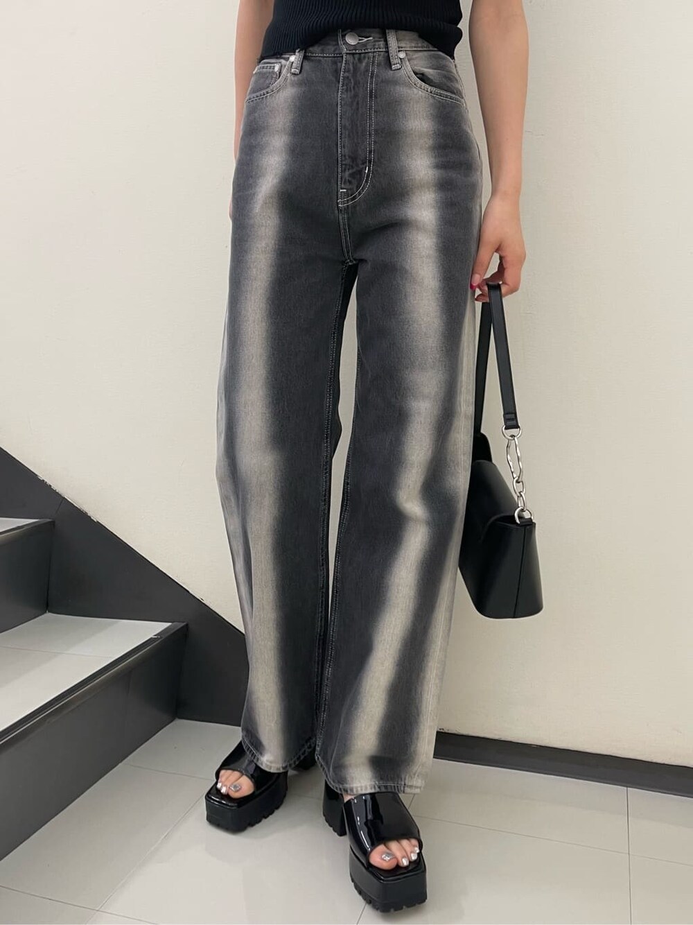 ブラック系のサンダル、ブラック系のハンドバッグ、ブラック系のデニムパンツを着用したレディースの春コーディネートの8枚目の写真