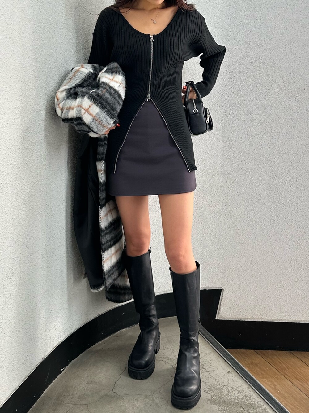 グレー系のスカート、ブラック系のニット/セーター、その他のチェスターコートを着用したレディースの冬コーディネートの4枚目の写真