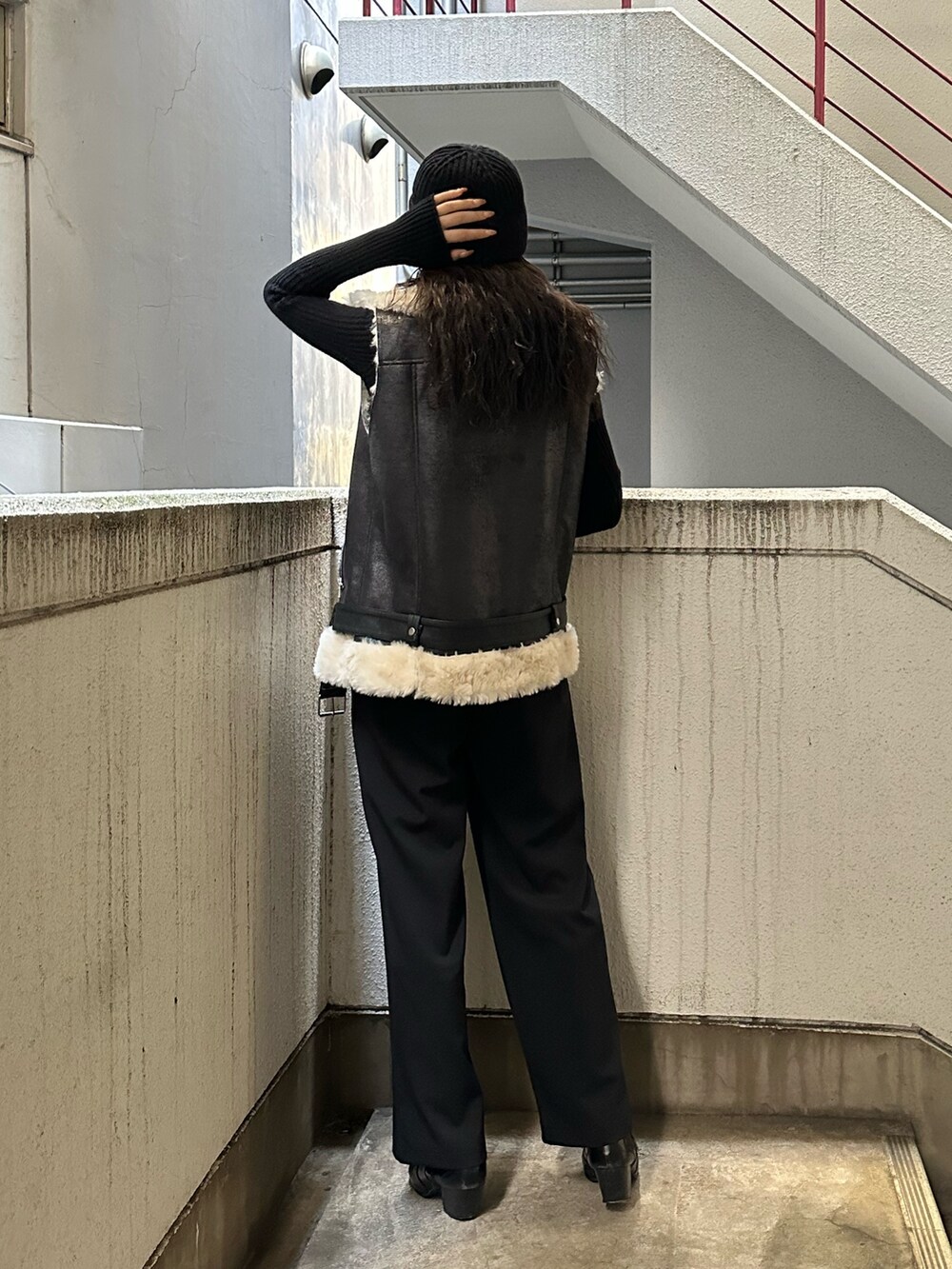 ブラック系のその他パンツ、ブラック系のブーツ、ブラック系のムートンコートを着用したレディースの秋コーディネートの2枚目の写真