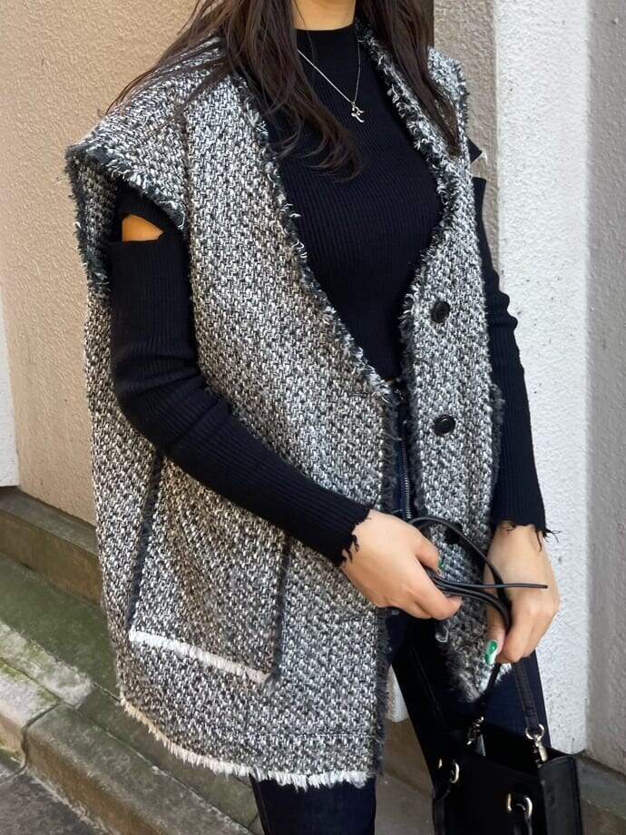 ブルー系のデニムパンツ、グレー系のベスト、ブラック系のニット/セーターを着用したレディースの秋コーディネートの4枚目の写真