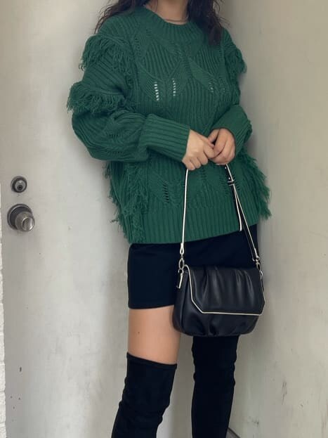 グリーン系のニット/セーター、ブラック系のブーツ、ブラック系のショルダーバッグを着用したレディースの秋コーディネートの3枚目の写真