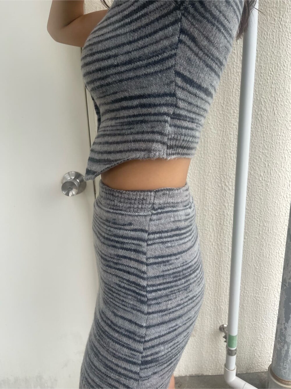 ブラック系のブーツ、ブラック系のスカート、ブラック系のニット/セーターを着用したレディースの夏コーディネートの6枚目の写真