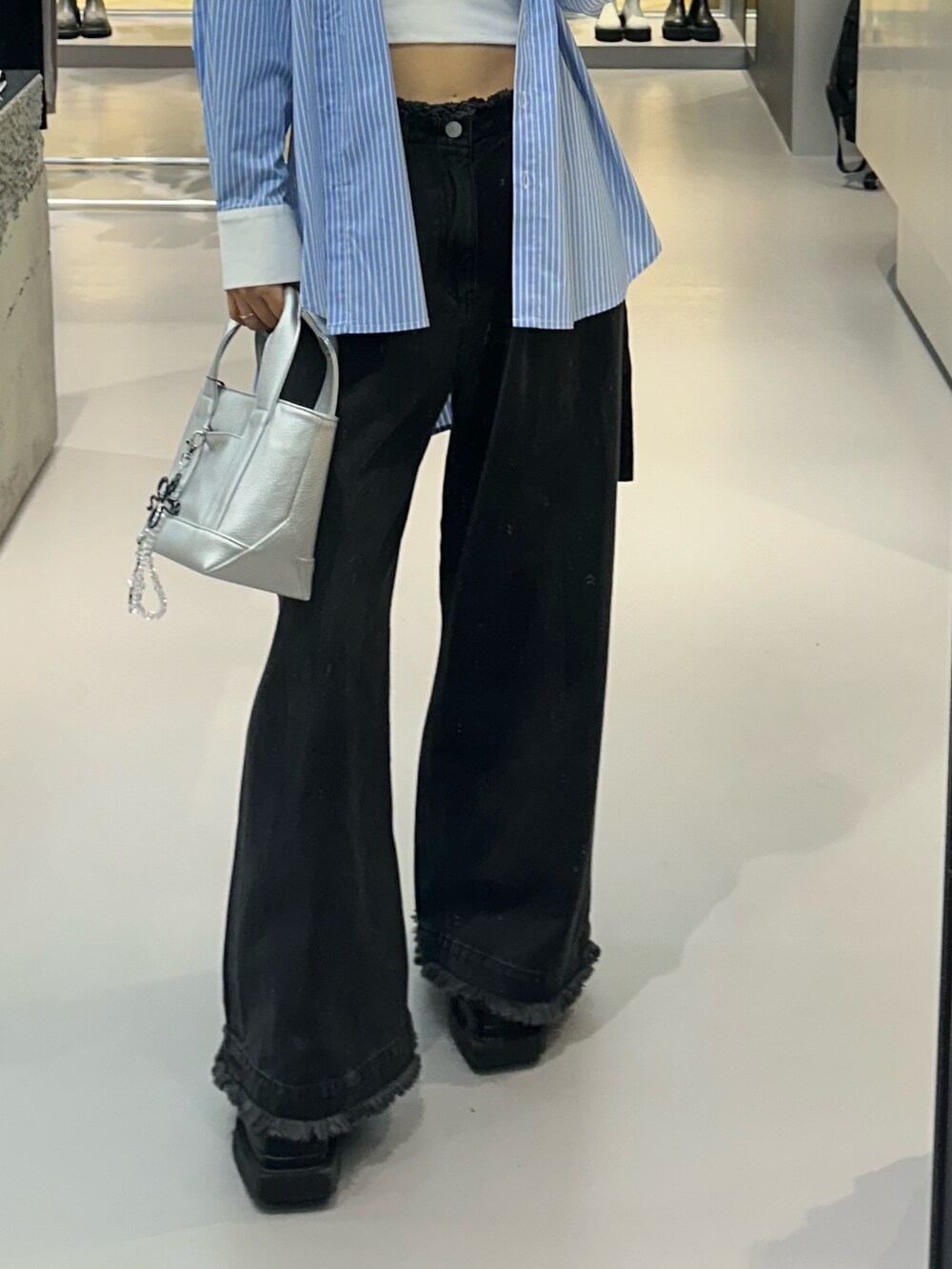 ブラック系のデニムパンツ、ホワイト系のキャミソール、ブルー系のシャツ/ブラウスを着用したレディースの冬コーディネートの5枚目の写真