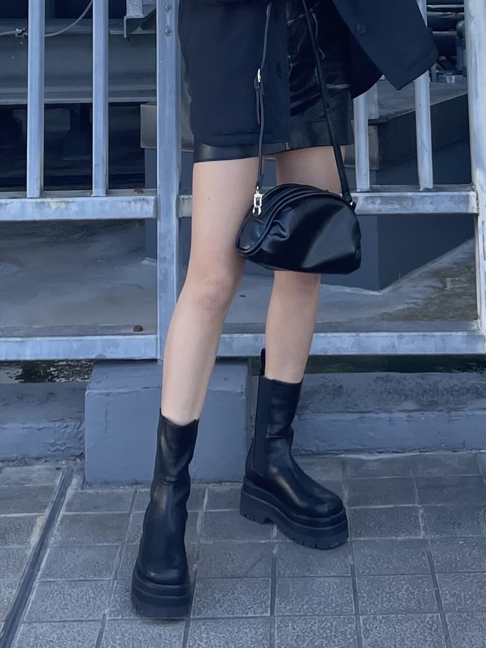 ブラック系のブルゾン、ブラック系のスカート、ホワイト系のTシャツ/カットソーを着用したレディースの秋コーディネートの8枚目の写真