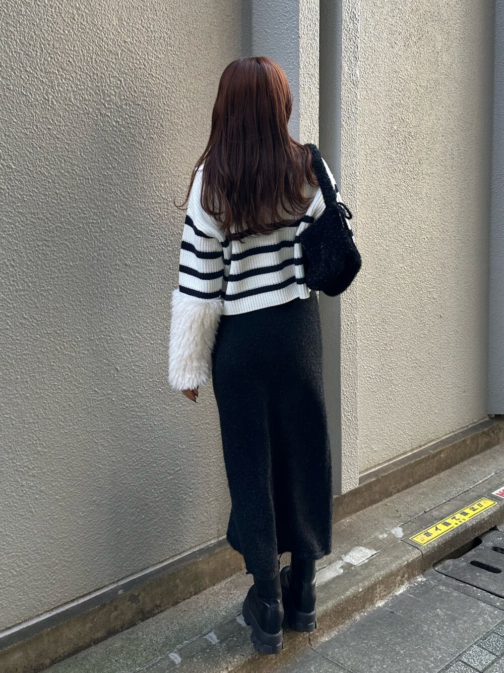 ブラック系のスカート、ブルー系のニット/セーターを着用したレディースの秋コーディネートの3枚目の写真