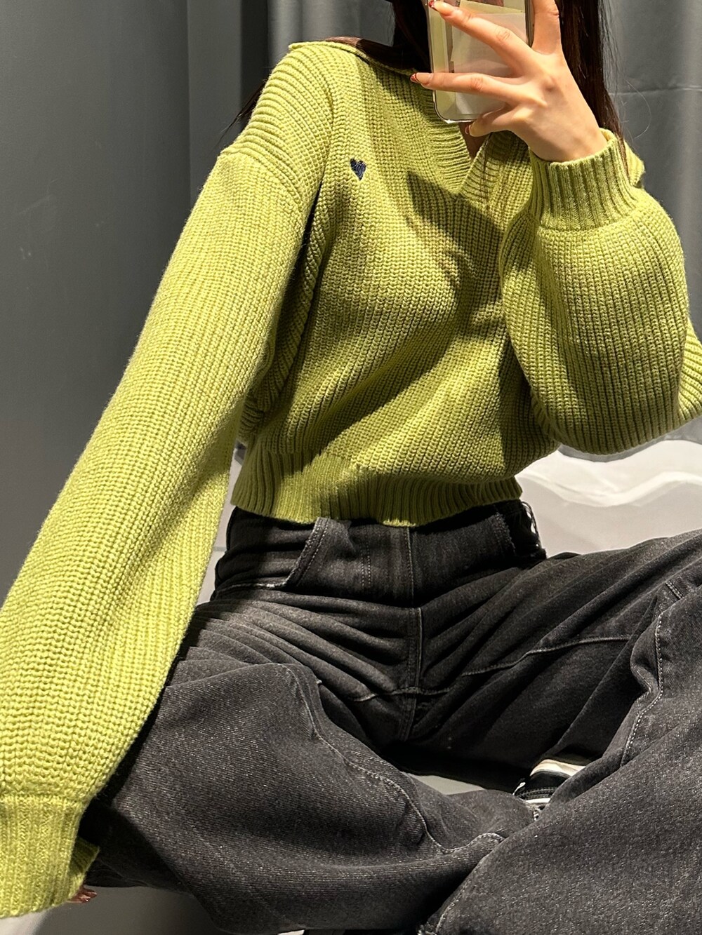 ブラック系のデニムパンツ、グリーン系のニット/セーター、ブラック系のハットを着用したレディースの冬コーディネートの6枚目の写真
