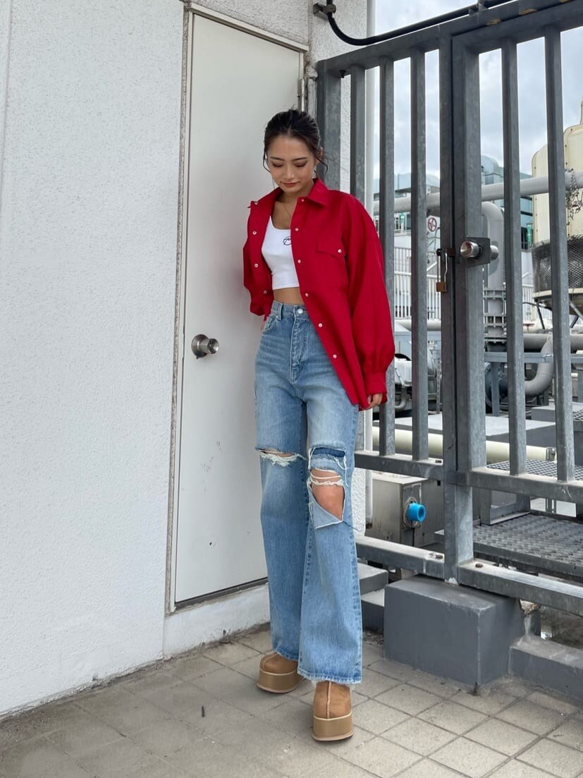 ブルー系のデニムパンツ、ベージュ系のスリッポン、レッド系のシャツ/ブラウスを着用したレディースの秋コーディネートの2枚目の写真