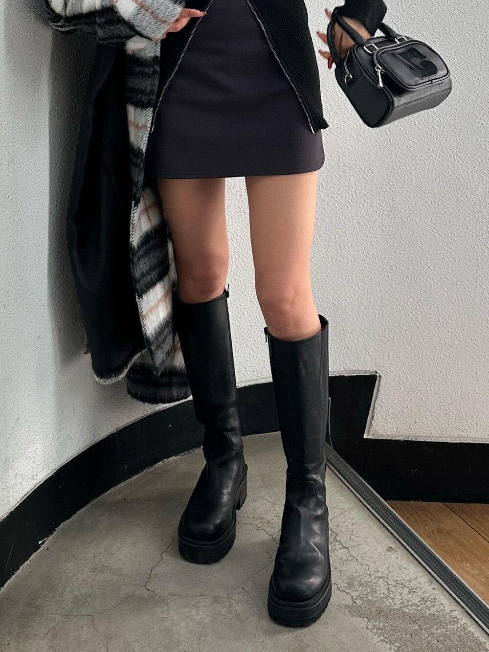 グレー系のスカート、ブラック系のニット/セーター、その他のチェスターコートを着用したレディースの冬コーディネートの7枚目の写真