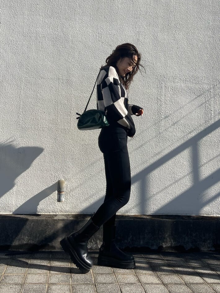 ブラック系のデニムパンツ、グリーン系のボディバッグ/ウエストポーチ、ブラック系のカーディガン/ボレロを着用したレディースの冬コーディネートの3枚目の写真