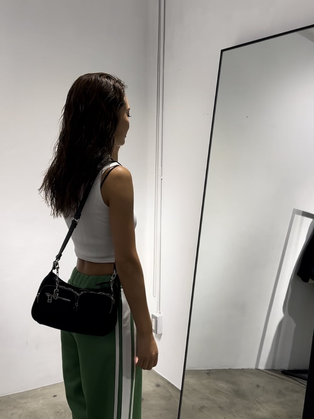 ホワイト系のタンクトップ、グリーン系のその他パンツ、ブラック系のハンドバッグを着用したレディースの秋コーディネートの2枚目の写真