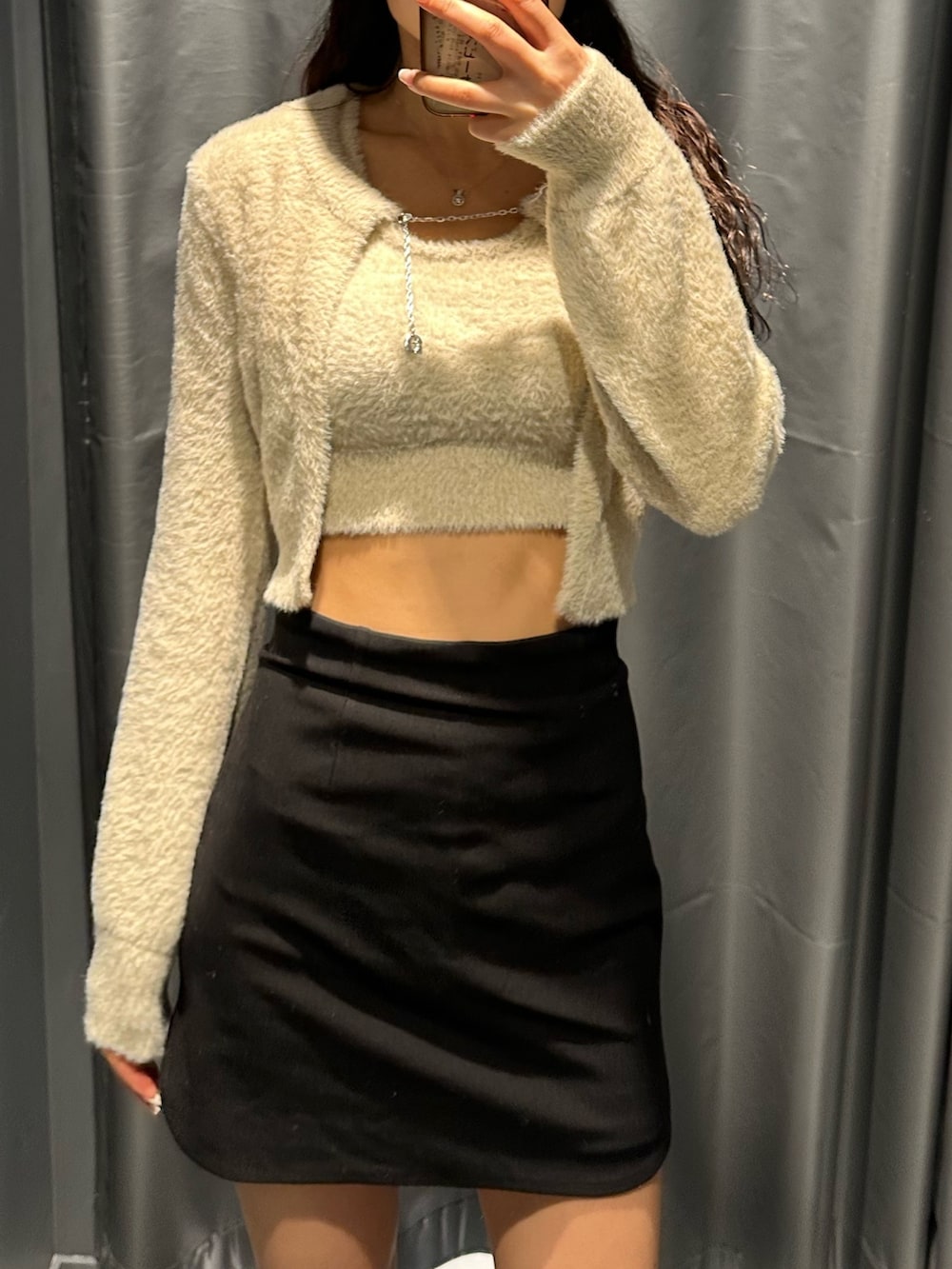 ブラック系のスカート、ホワイト系のニット/セーター、その他のブーツを着用したレディースの冬コーディネートの4枚目の写真