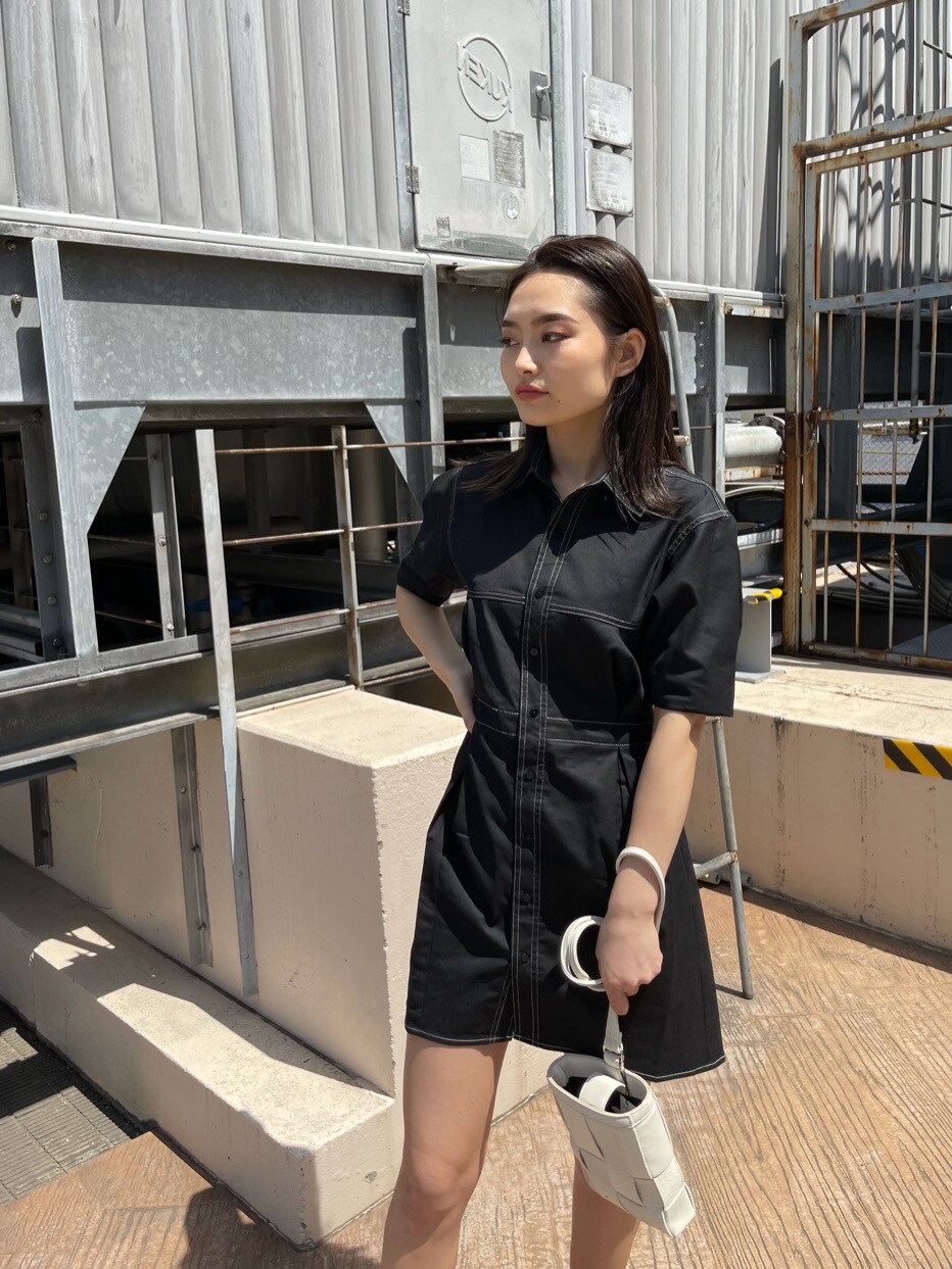 ブラック系のワンピース、ブラック系のサンダル、ホワイト系のショルダーバッグを着用したレディースの春コーディネートの2枚目の写真