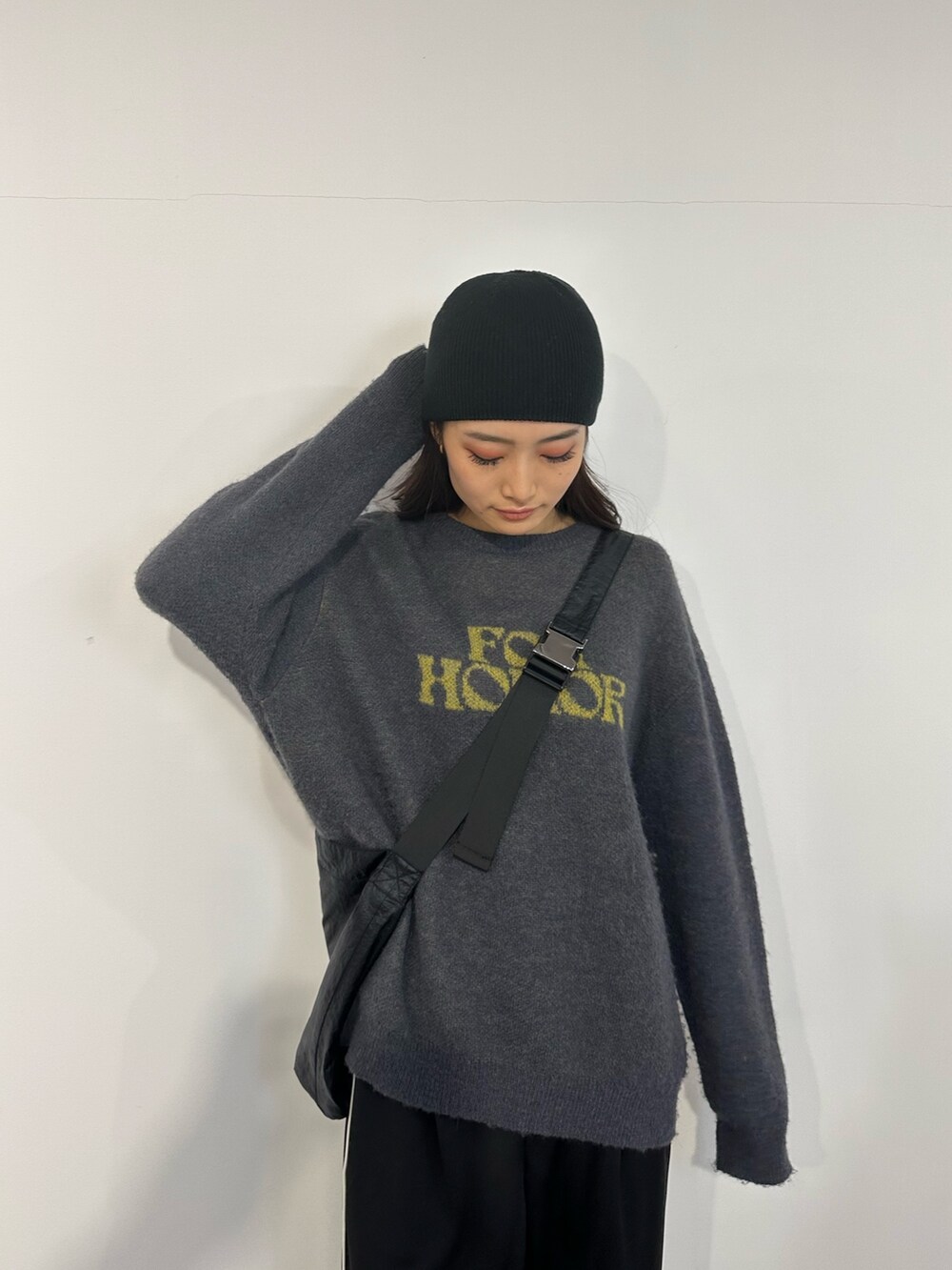 ブルー系のニット/セーター、ブラック系のスラックス、ブラック系のブーツを着用したレディースの冬コーディネートの4枚目の写真