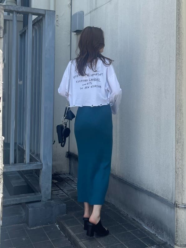 ブラック系のハンドバッグ、ホワイト系のTシャツ/カットソー、ブラック系のサンダルを着用したレディースの春コーディネートの3枚目の写真