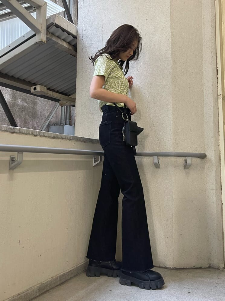 ブラック系のブーツ、ブラック系のハンドバッグ、ブラック系のデニムパンツを着用したレディースの春コーディネートの3枚目の写真