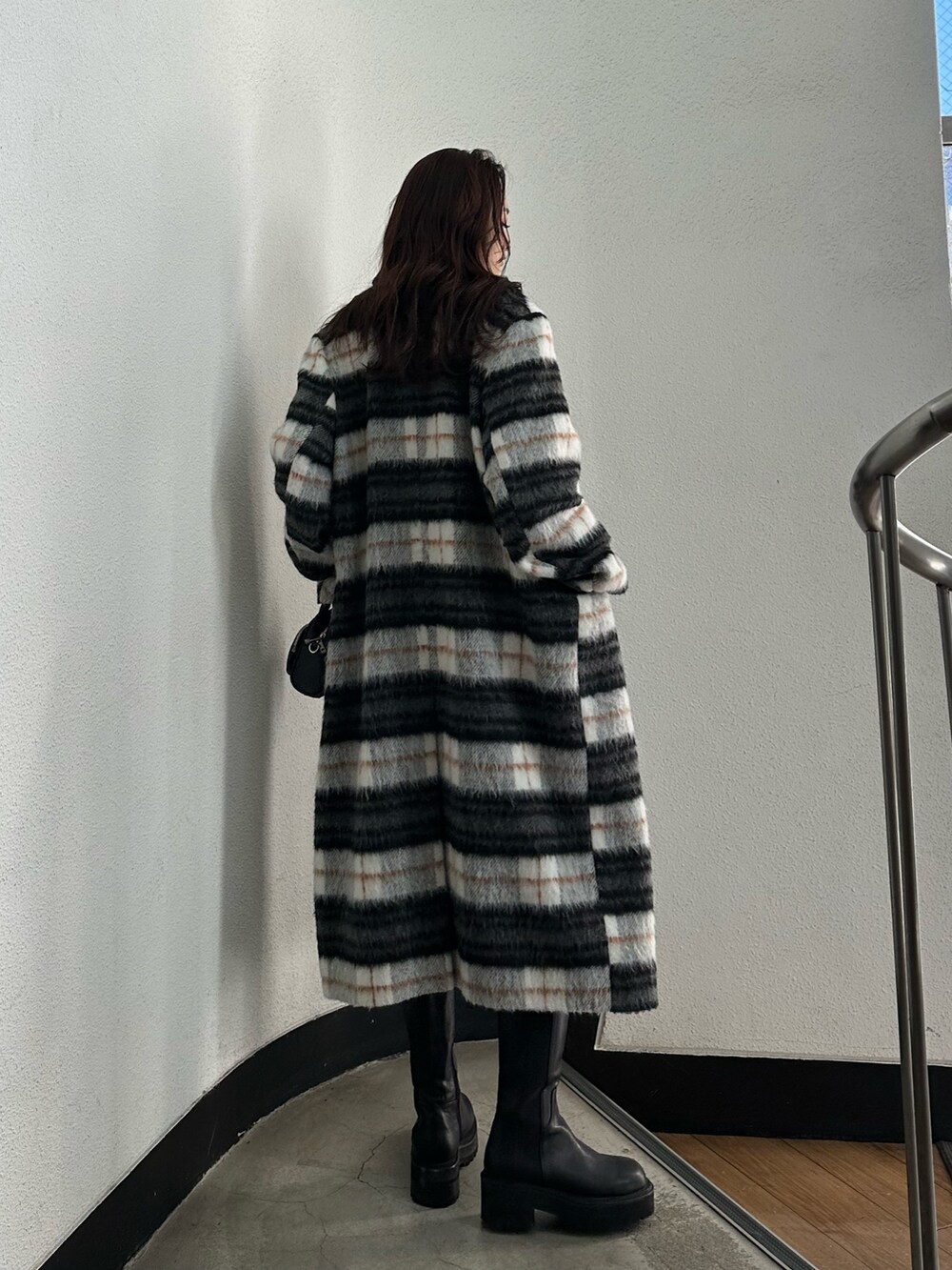 グレー系のスカート、ブラック系のニット/セーター、その他のチェスターコートを着用したレディースの冬コーディネートの3枚目の写真