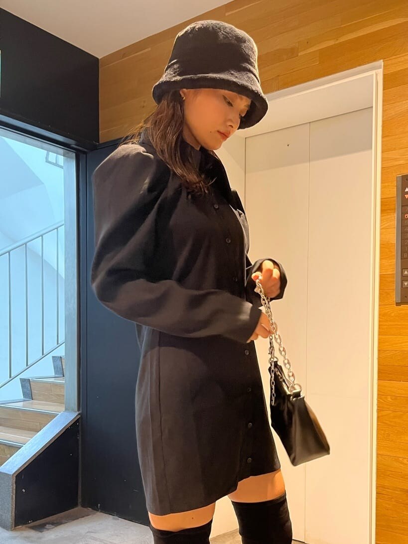 ブラック系のワンピース、ブラック系のブーツ、ブラック系のハンドバッグを着用したレディースの秋コーディネートの5枚目の写真