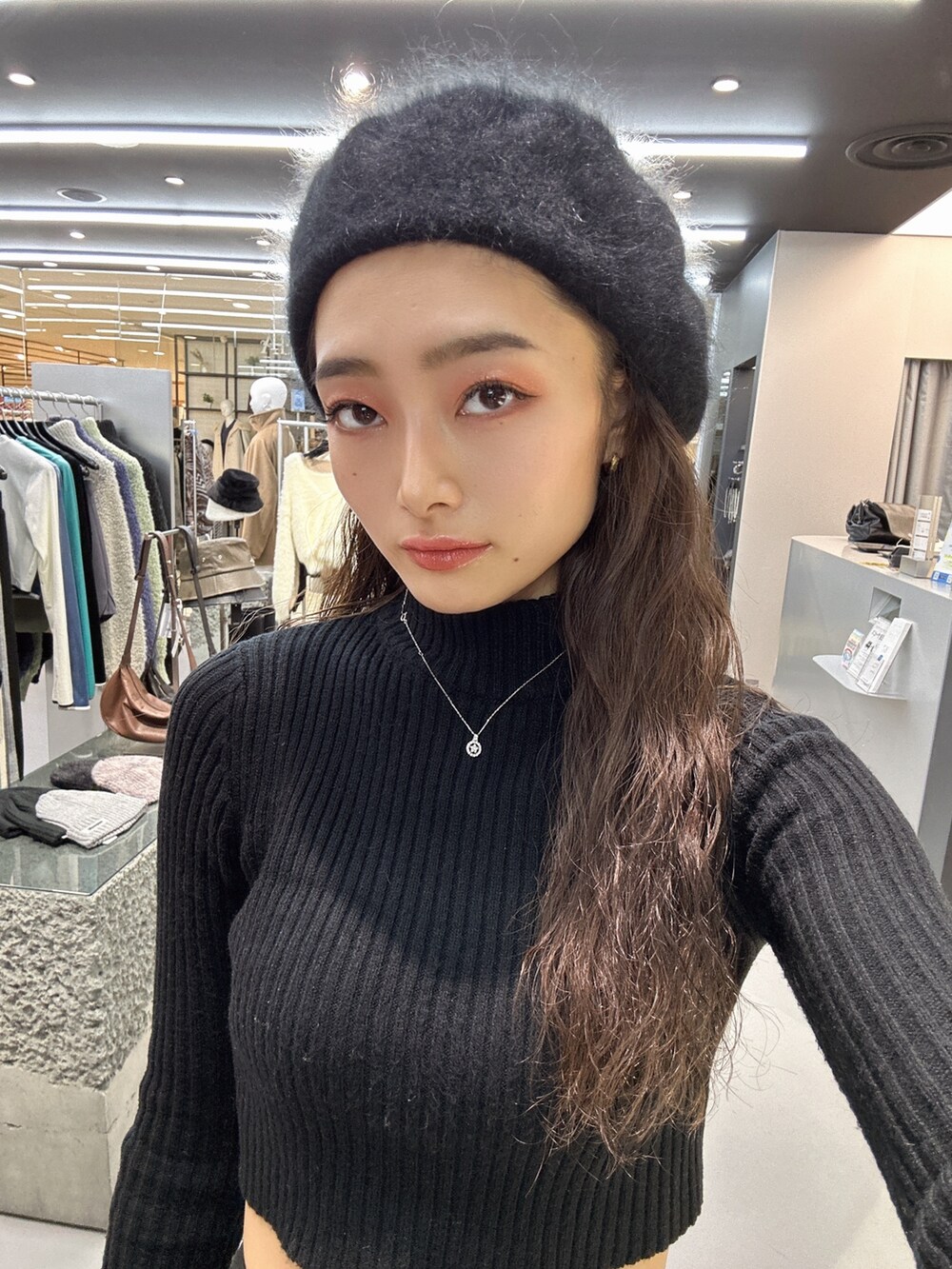 ブラック系のブルゾン、ブラック系のニット/セーター、ブラック系のブーツを着用したレディースの冬コーディネートの7枚目の写真