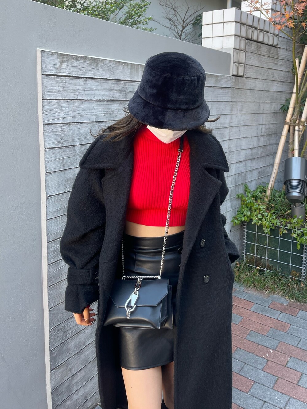 ブラック系のチェスターコート、その他のスカート、レッド系のニット/セーターを着用したレディースの冬コーディネートの7枚目の写真