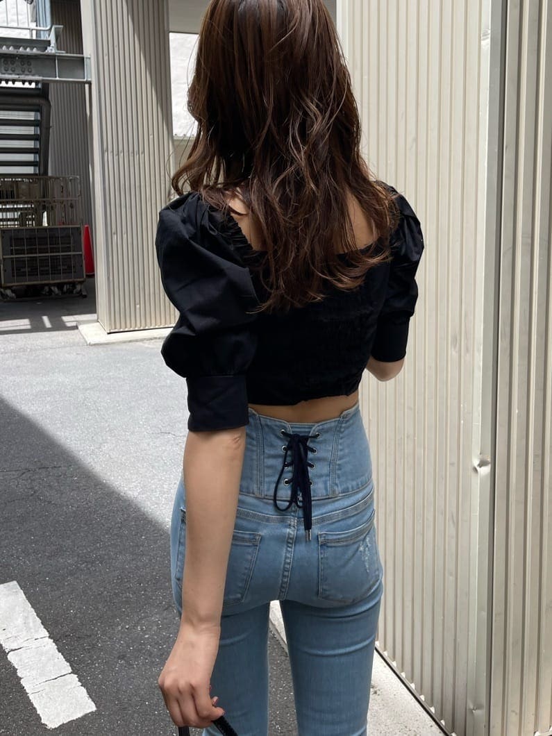 ブラック系のサンダル、ブラック系のTシャツ/カットソー、ブルー系のデニムパンツを着用したレディースの夏コーディネートの5枚目の写真