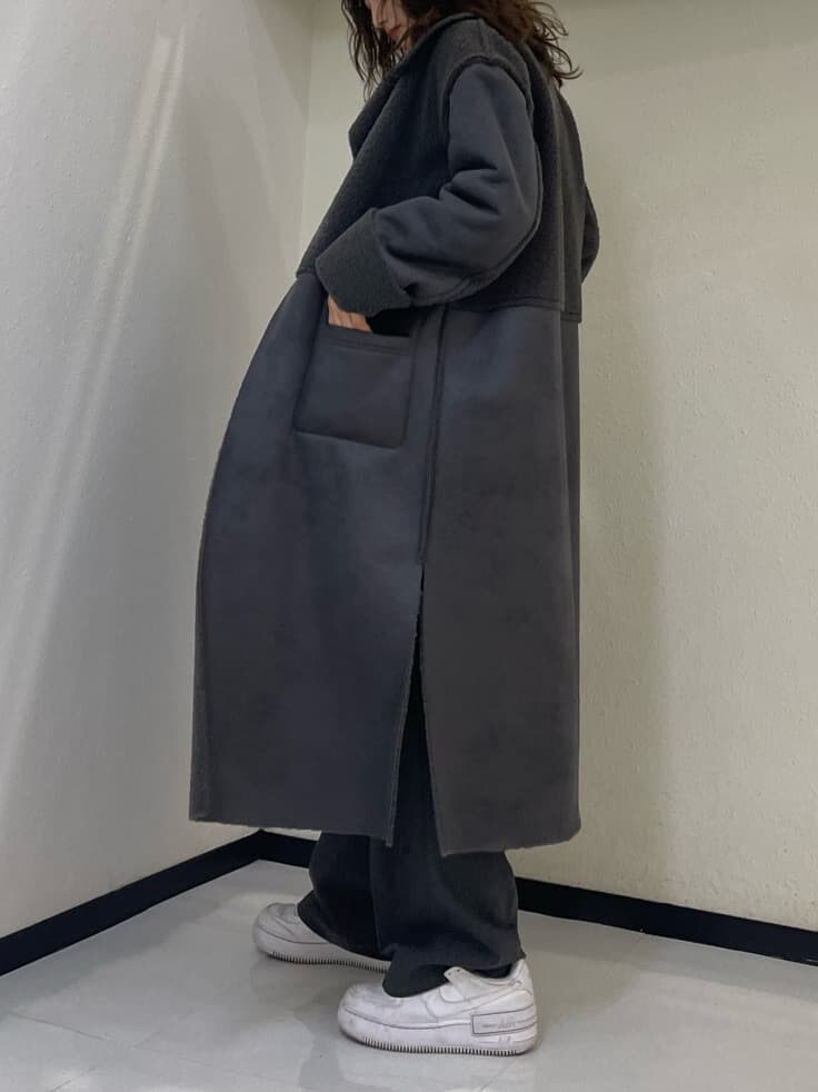 グレー系のムートンコート、ホワイト系のTシャツ/カットソー、グレー系のその他パンツを着用したレディースの冬コーディネートの5枚目の写真