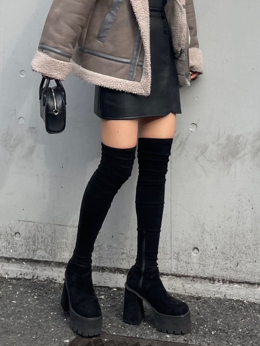 グレー系のブルゾン、その他のスカート、ブラック系のブーツを着用したレディースの秋コーディネートの10枚目の写真