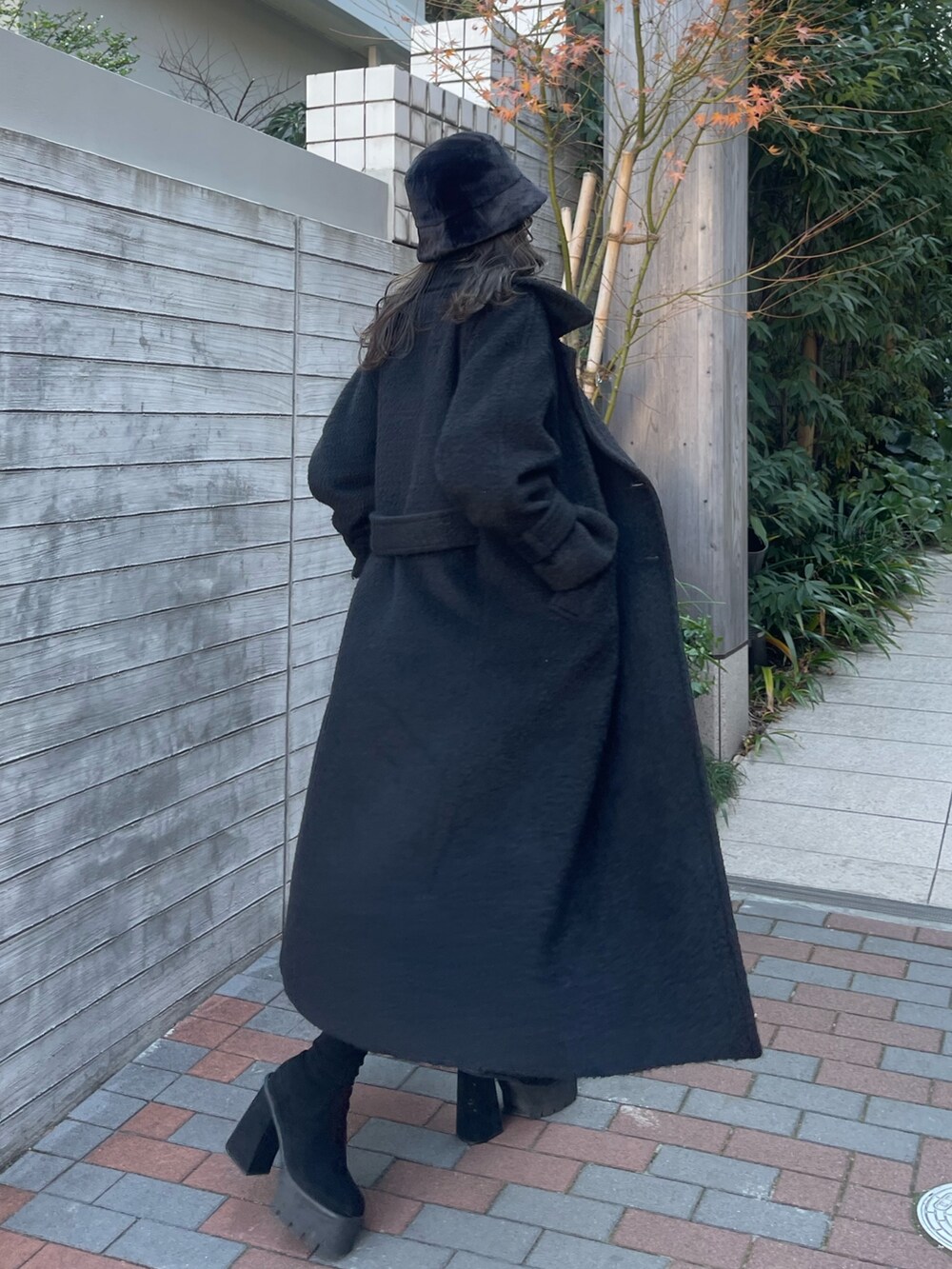 ブラック系のチェスターコート、その他のスカート、レッド系のニット/セーターを着用したレディースの冬コーディネートの5枚目の写真