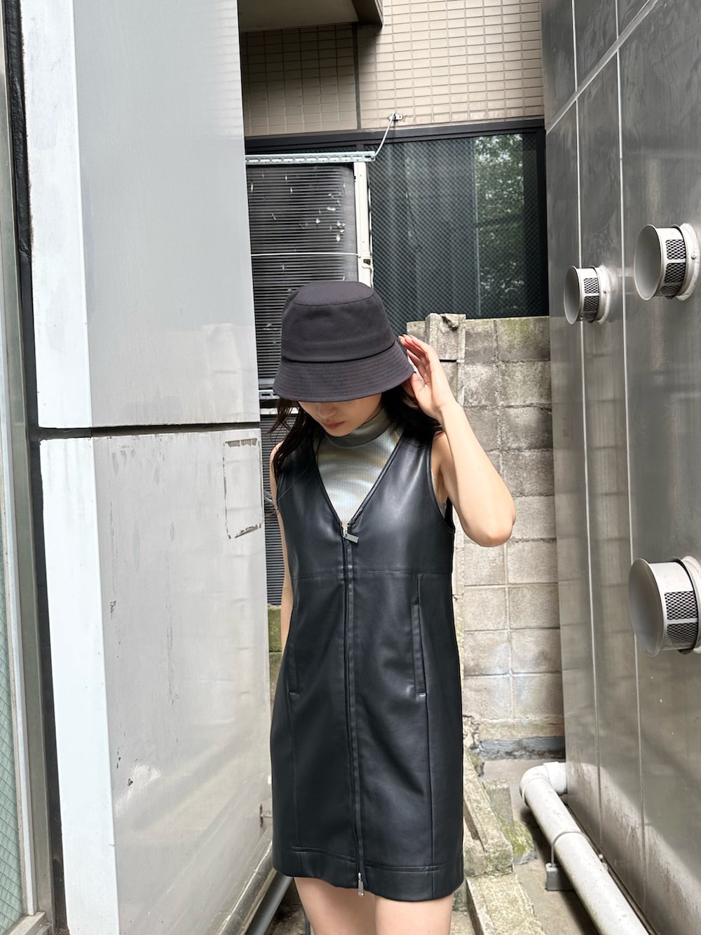 ブラック系のワンピース、ブラック系のブーツ、その他のタンクトップを着用したレディースの夏コーディネートの3枚目の写真