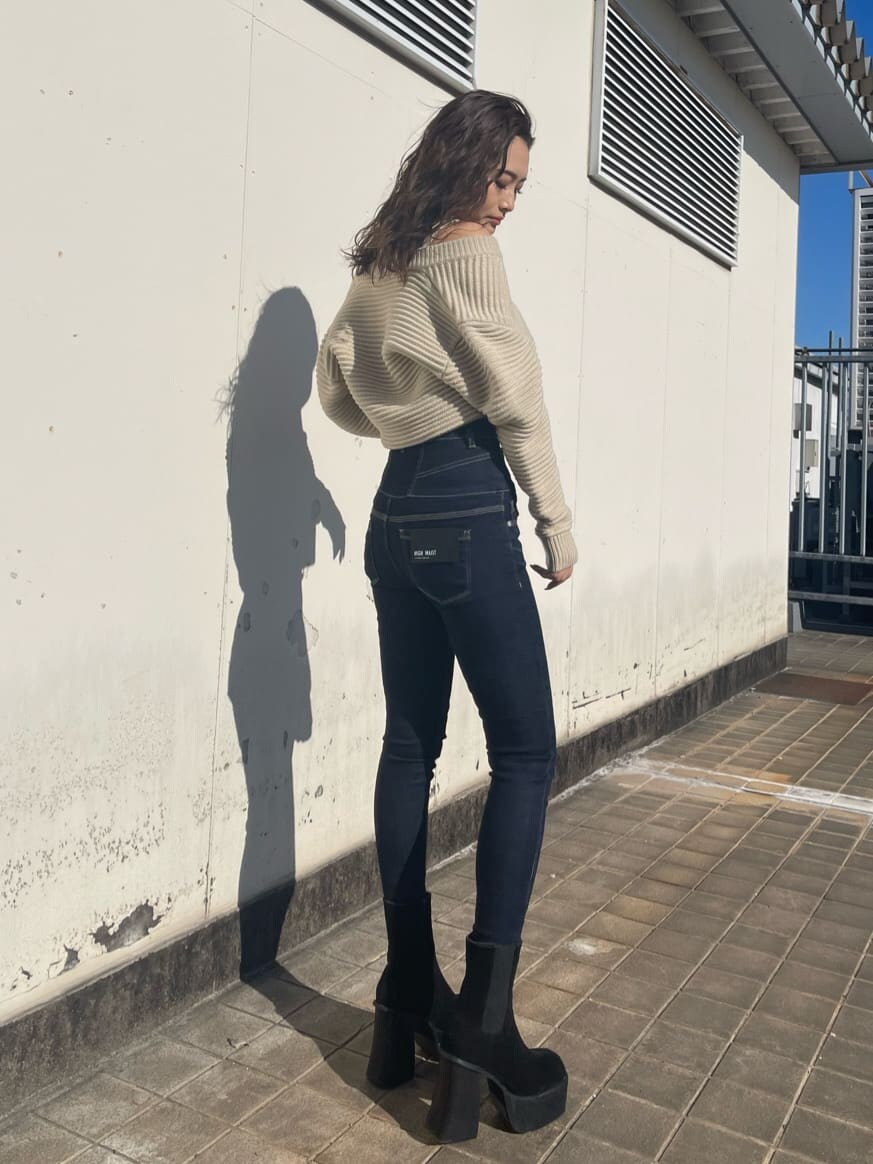 ホワイト系のニット/セーター、ブルー系のデニムパンツ、ブラック系のブーツを着用したレディースの冬コーディネートの3枚目の写真